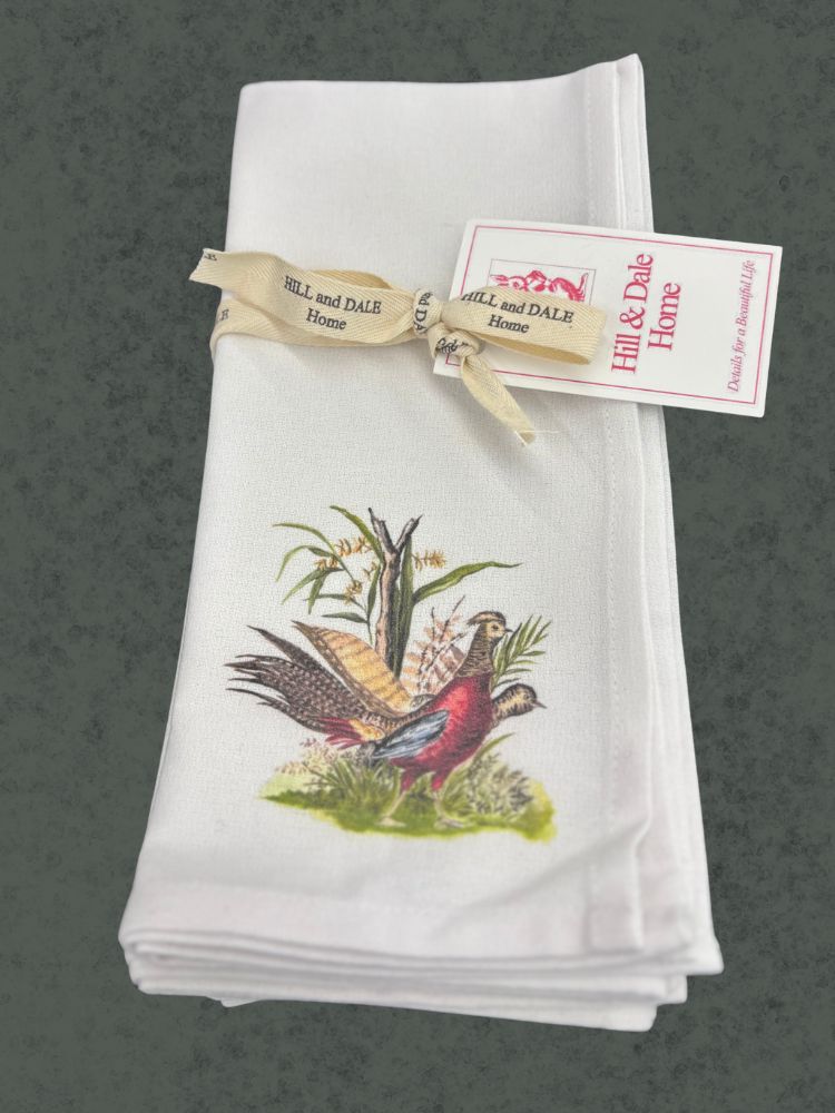 Folded cloth napkin with a vintage-style illustration of two pheasants and corn stalks, tied with a cream Hill & Dale Home ribbon and tag.