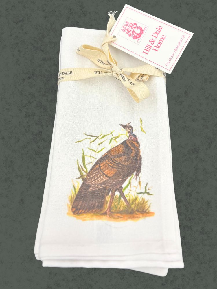 Cloth napkin set featuring a hand-illustrated wild turkey in autumn colors, bundled with a Hill & Dale Home ribbon and tag.