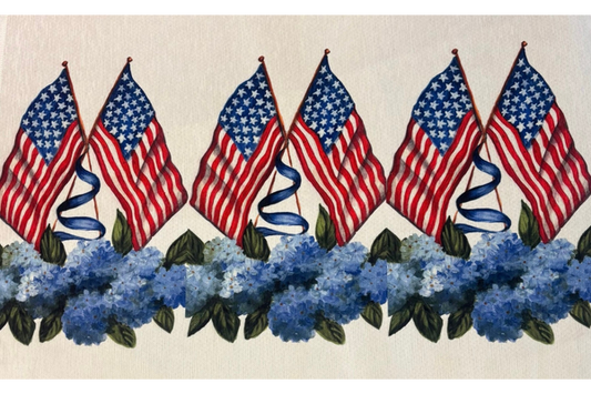 Indoor/outdoor rug featuring repeating American flags above blue hydrangea flowers and green leaves on a neutral background.