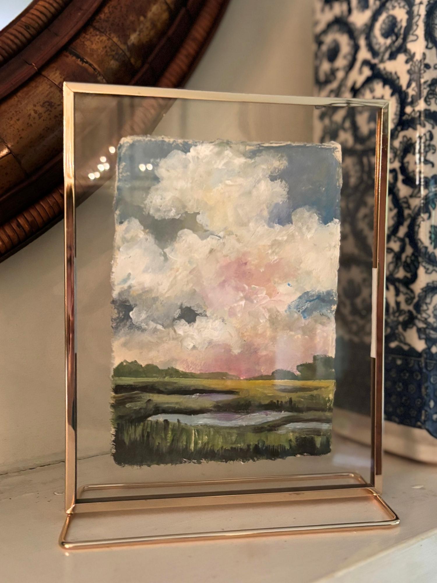Original acrylic painting of a soft sky with drifting clouds over a quiet Southern marsh, painted on handmade Lokta paper and framed in a floating brass frame.
