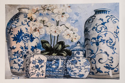 Photo of a paper placemat on a white background showcasing chinoiserie vases and white orchids