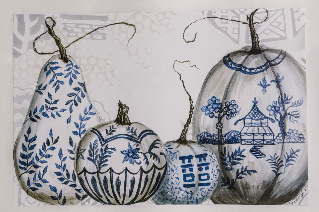 Photo of a rectangular paper placemat with blue and white chinoiserie designs painted on pumpkins and squash