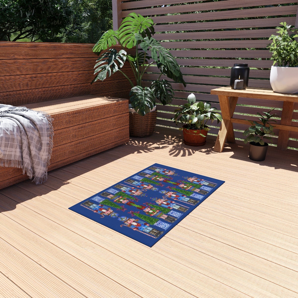 Photo of a whimsical holiday rug with a blue background featuring nutcrackers holding candy cane staffs and Christmas trees with a chinoiserie base. The rug is outdoors on a porch in front of a wooden bench.