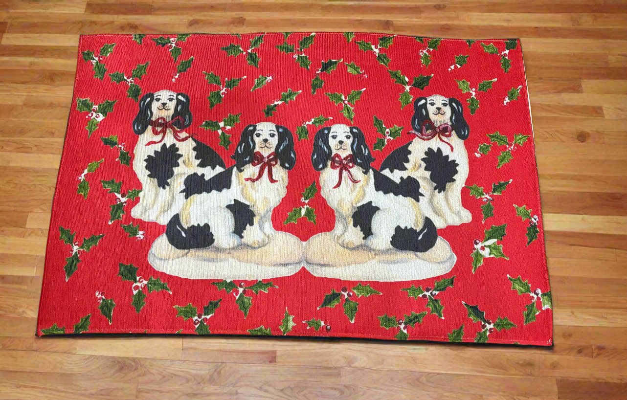 Photo of a red rug featuring four Staffordshire dogs with red bows surrounded by a holly pattern on a hardwood floor