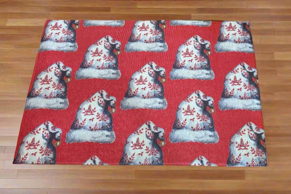 Photo of a red holiday rug with Santa hat designs on a hardwood floor