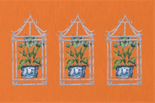 Photo of an orange rug with three pagodas. Each pagoda has a plant in a blue chinoiserie painted pot inside. 