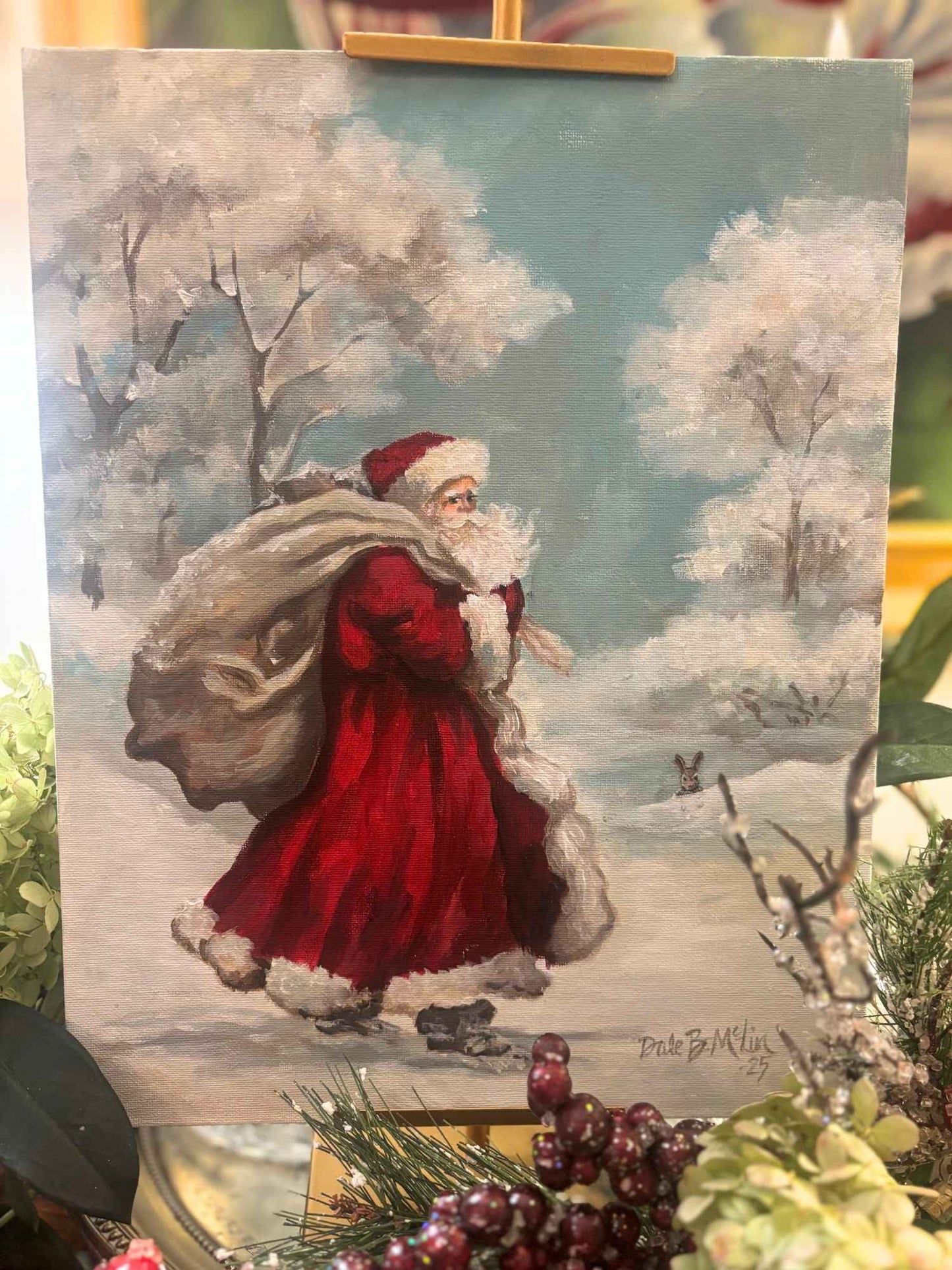 8x10 tabletop art print featuring Santa Claus in a red coat carrying a gift sack as he walks through a snowy woodland scene with frosted trees and a bunny in the background.
