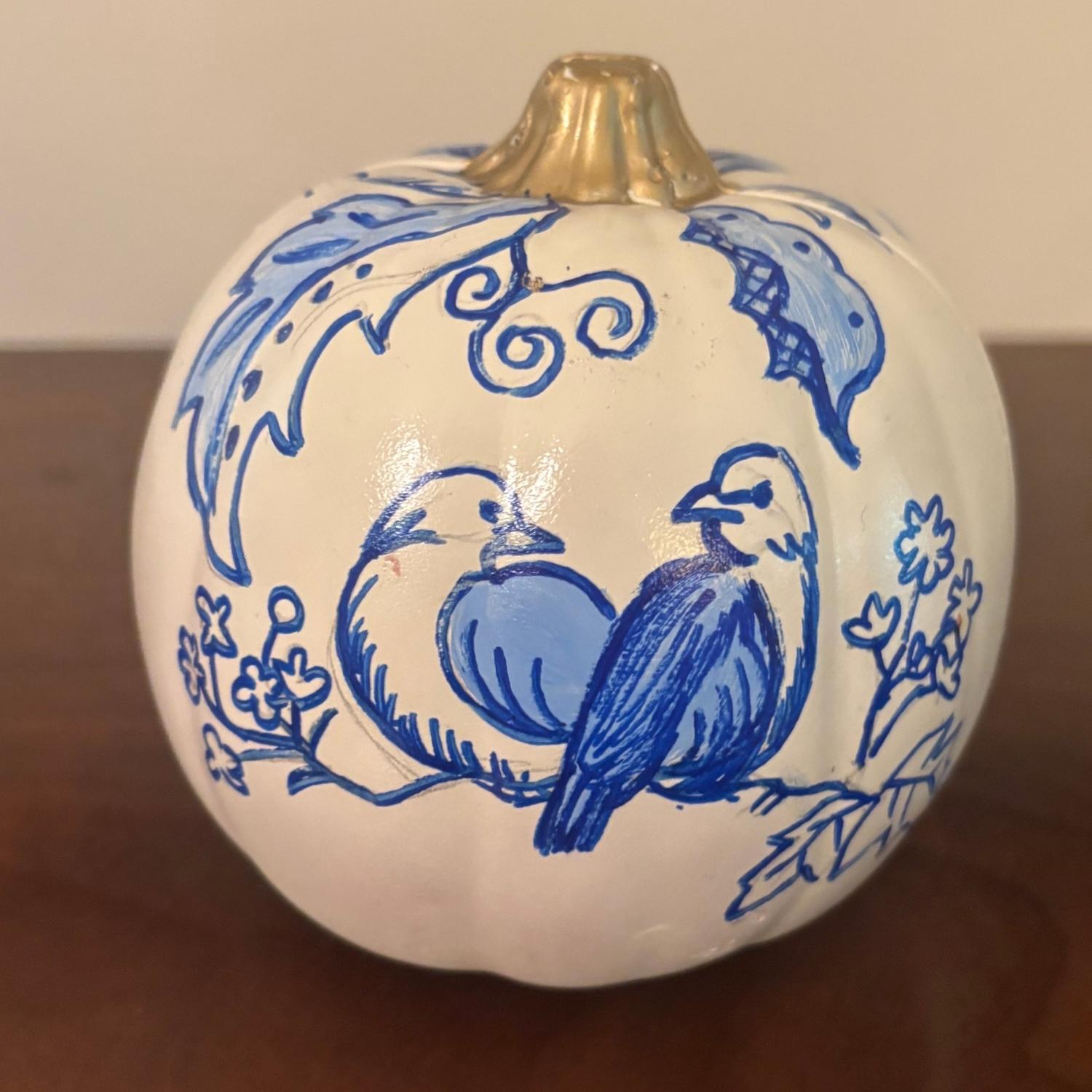 Hand-painted white chinoiserie pumpkin with two blue birds perched on a branch surrounded by florals.