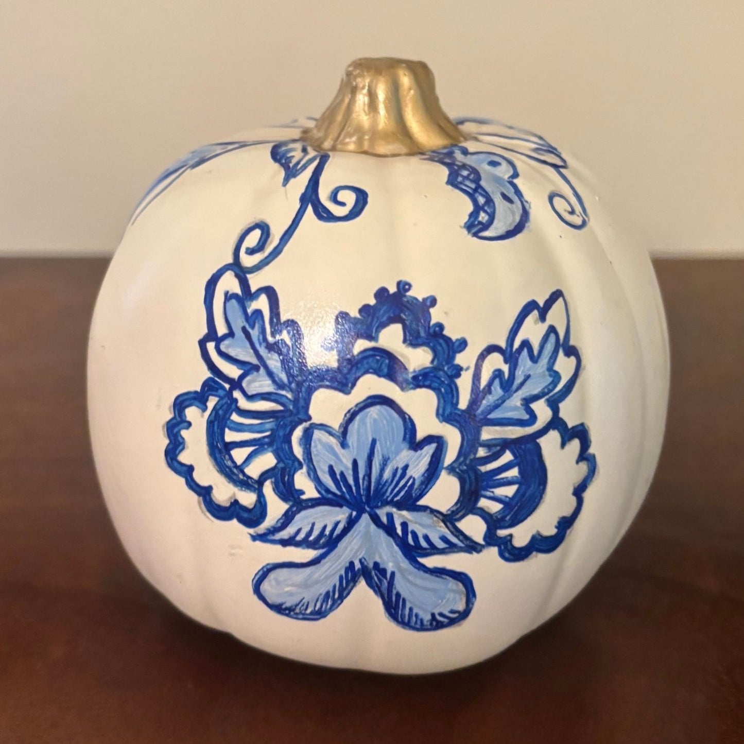 a detailed hand-painted decorative pumpkin with a blue blossom on a white background with gold stem