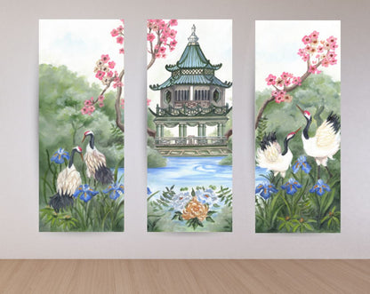 Cranes & Pagoda chinoiserie triptych displayed as three vertical canvas panels with cranes, a pagoda pavilion, cherry blossoms, blue irises, and calming water.