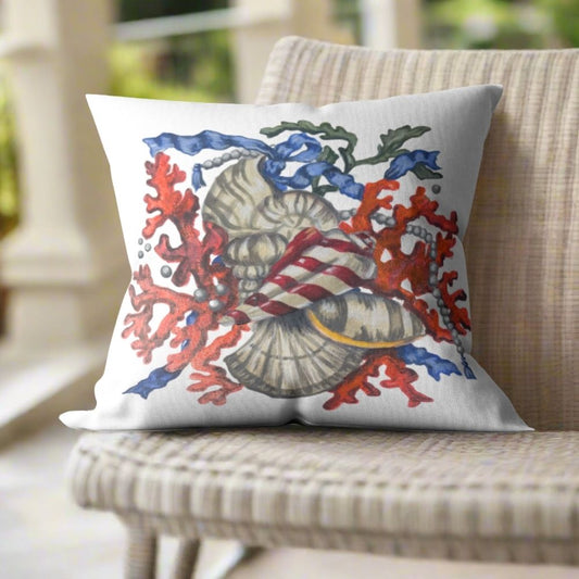 White throw pillow featuring Dale Barattini McLin artwork of sunset coral, seashells, pearls, and blue ribbon accents on a woven chair.